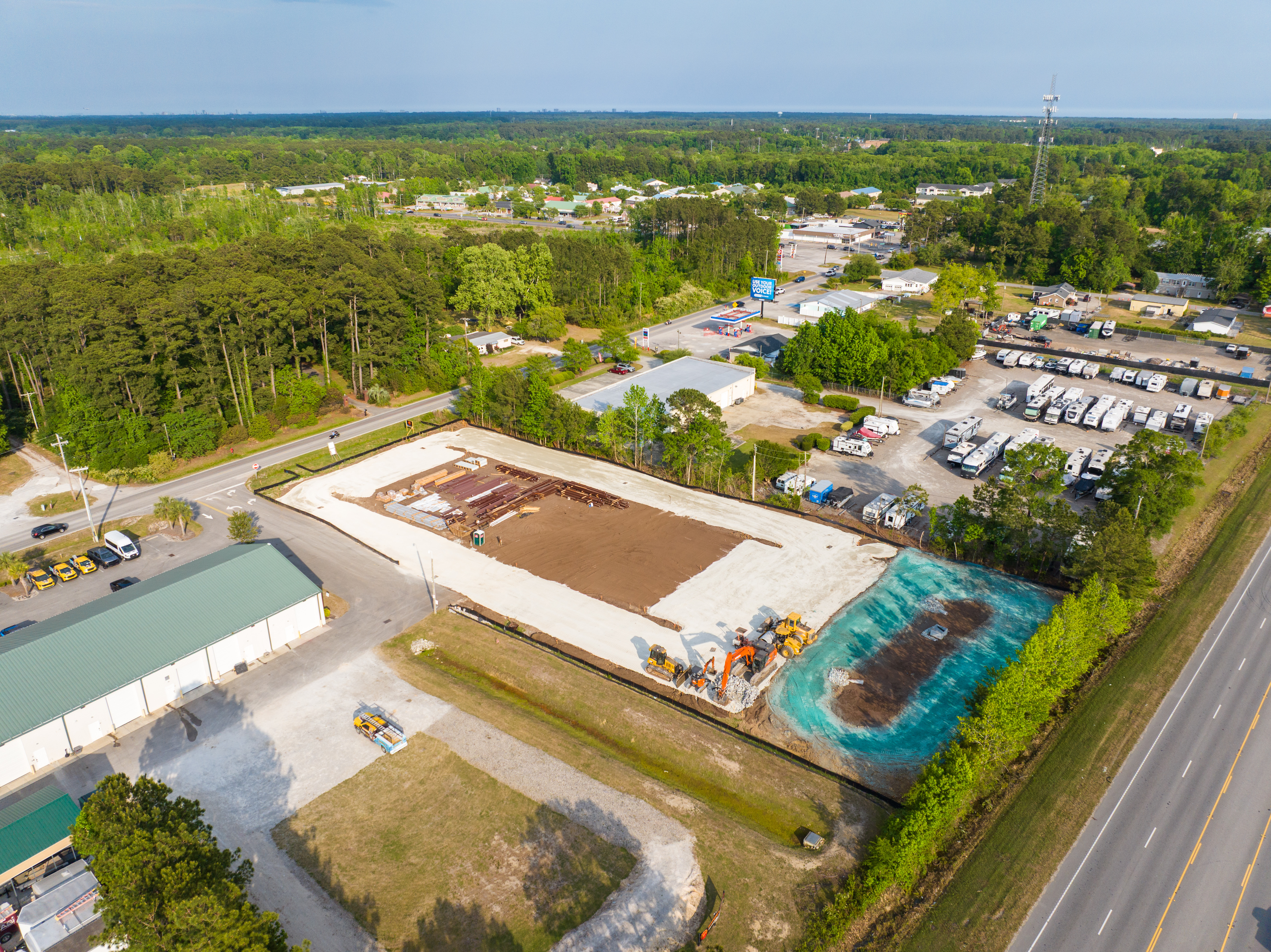 Ground-level drone view showing excavation and construction equipment