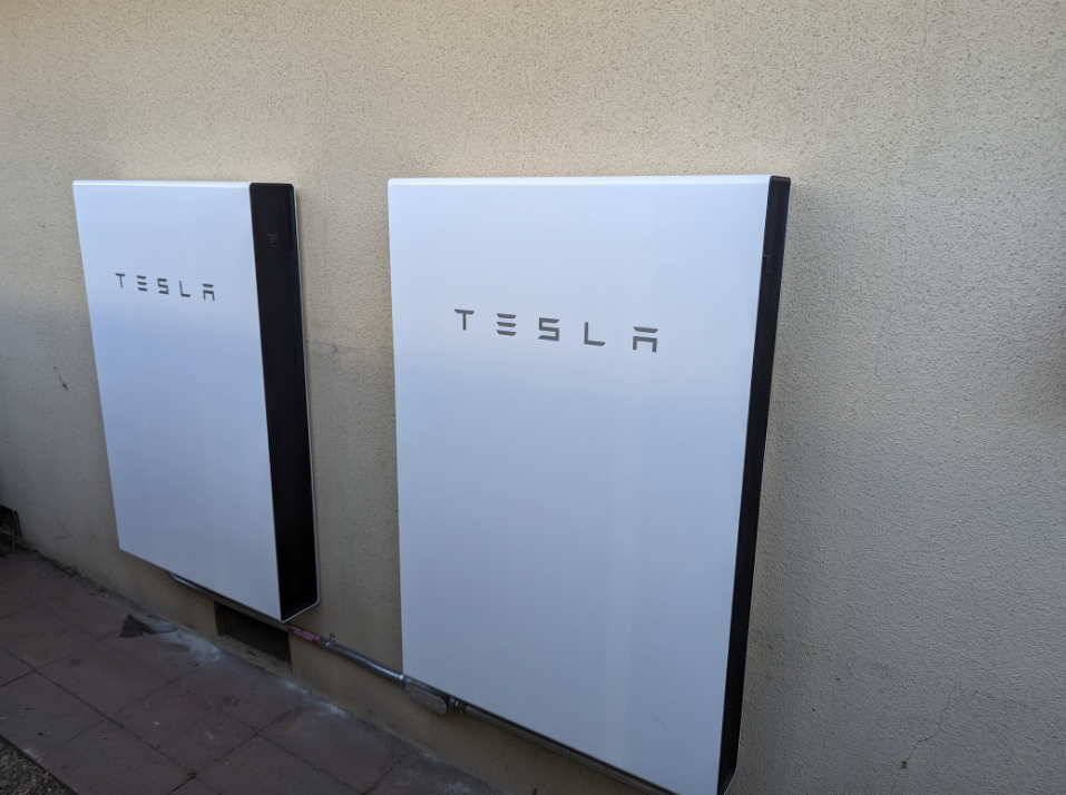 Happy family standing in front of their modern home with solar panels on the roof, symbolizing clean energy and long-term savings.