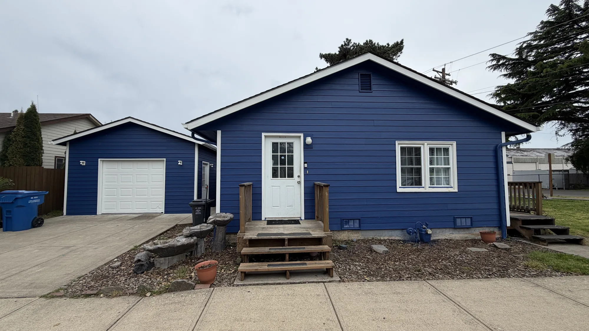 Blue home exterior with fresh exterior painting by Over The Top Painting & Remodeling