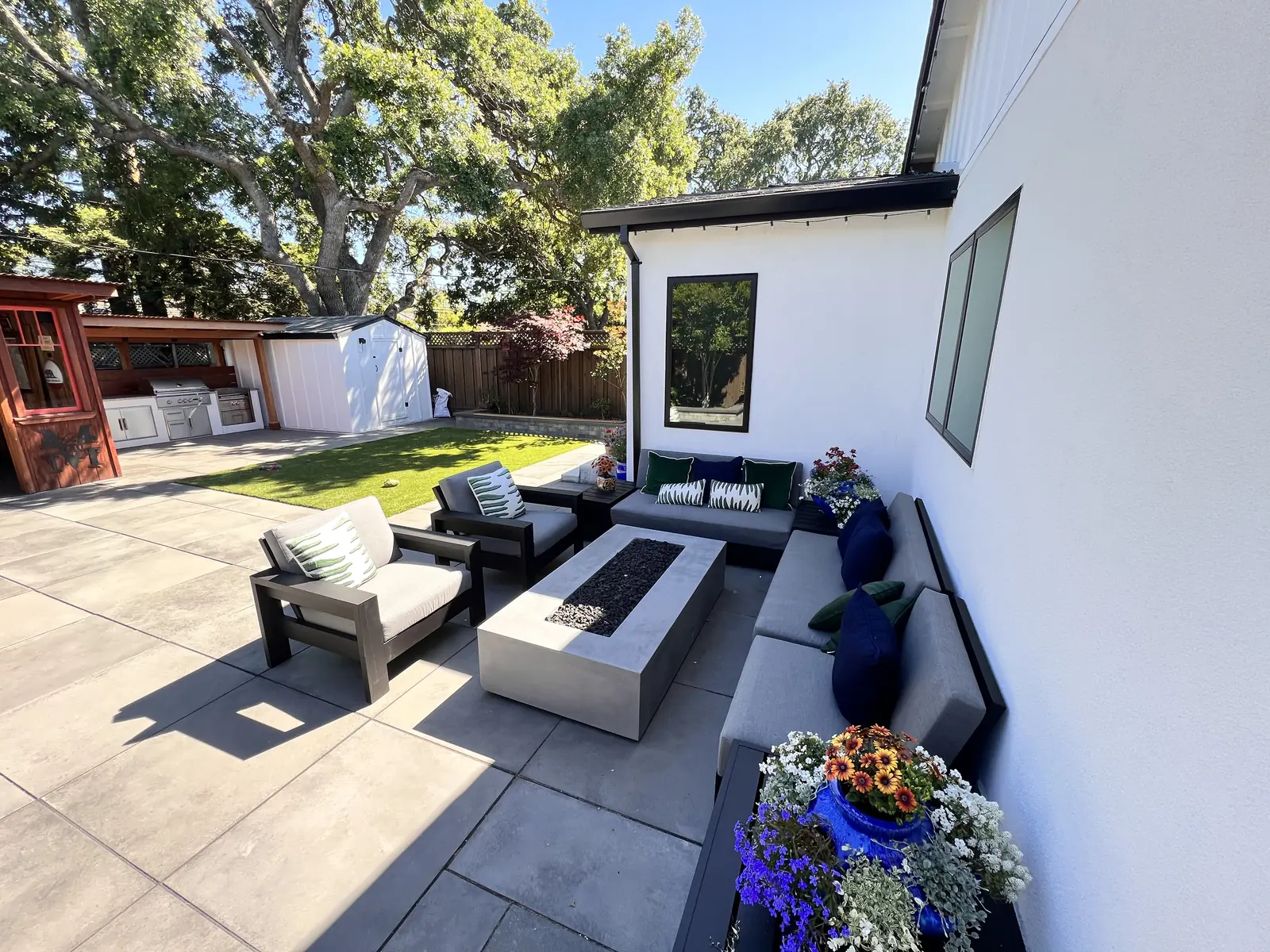Paver patio with outdoor seating and planters beside a modern home