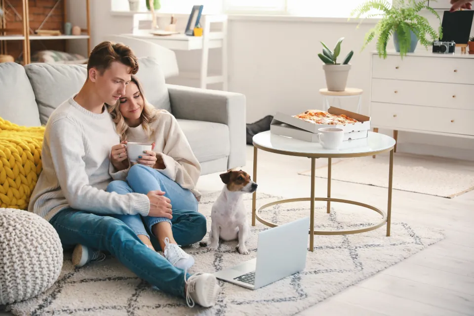 Young couple and their dog relaxing on the floor of their living room