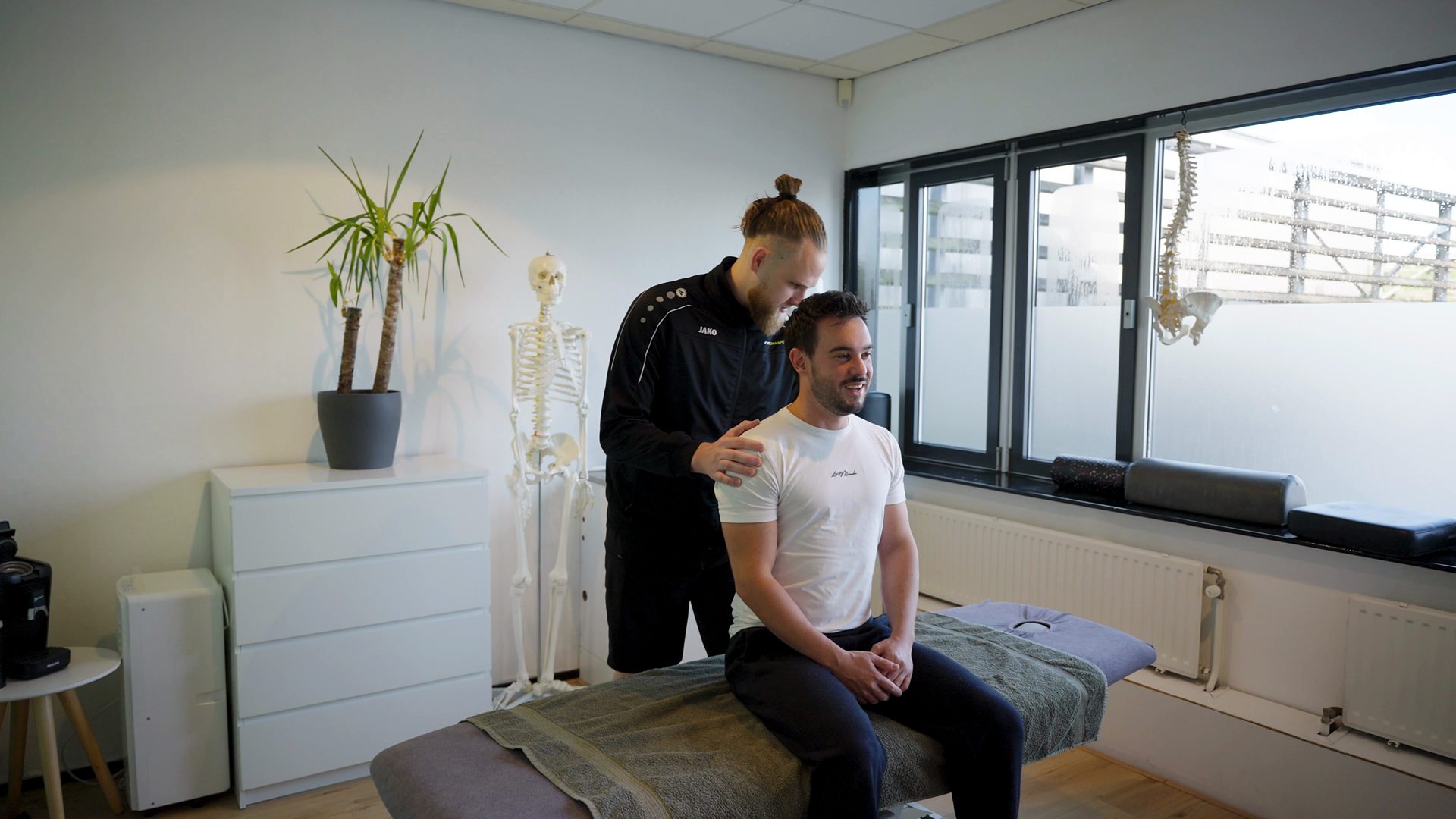Demi en een lachende pati&euml;nt in de behandelkamer