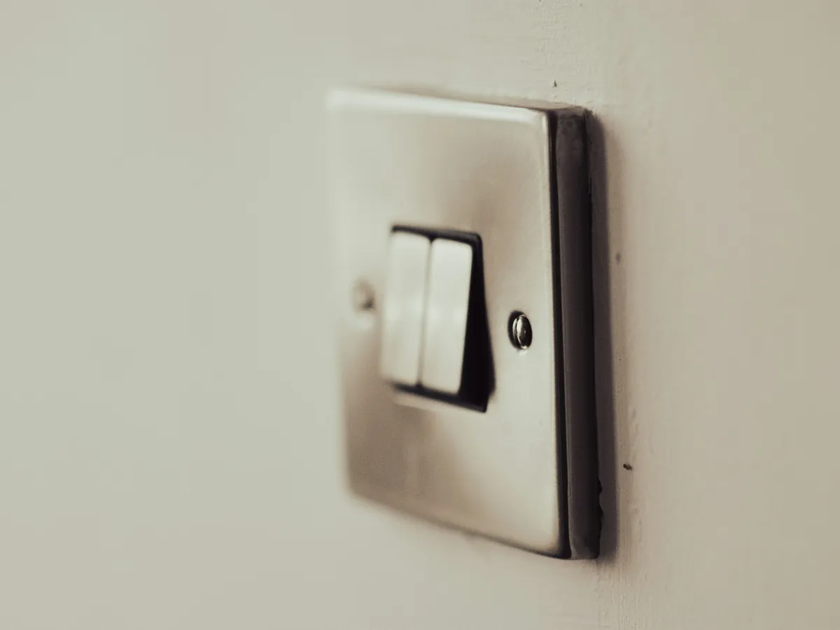 Brushed metal double light switch on a painted wall