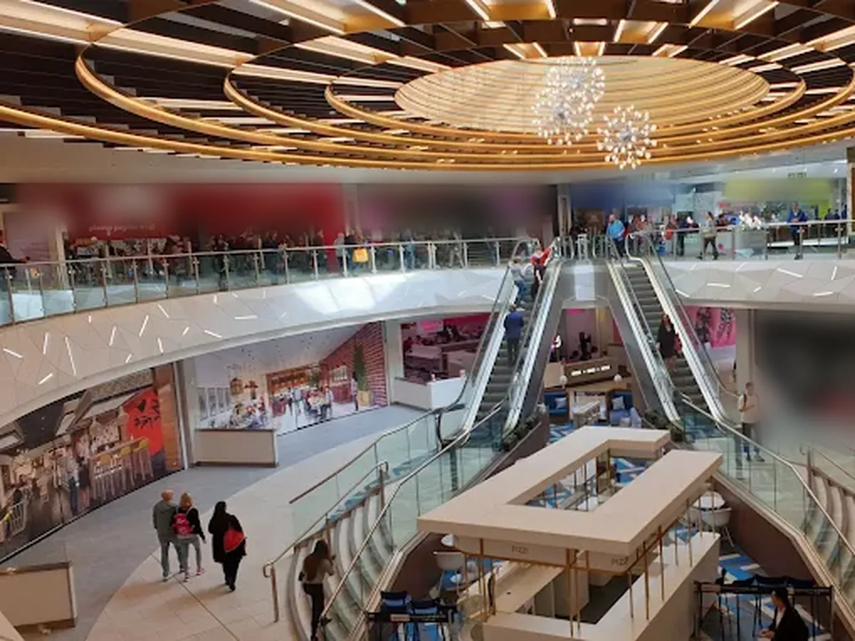 Shopping centre atrium with ring lighting and chandeliers
