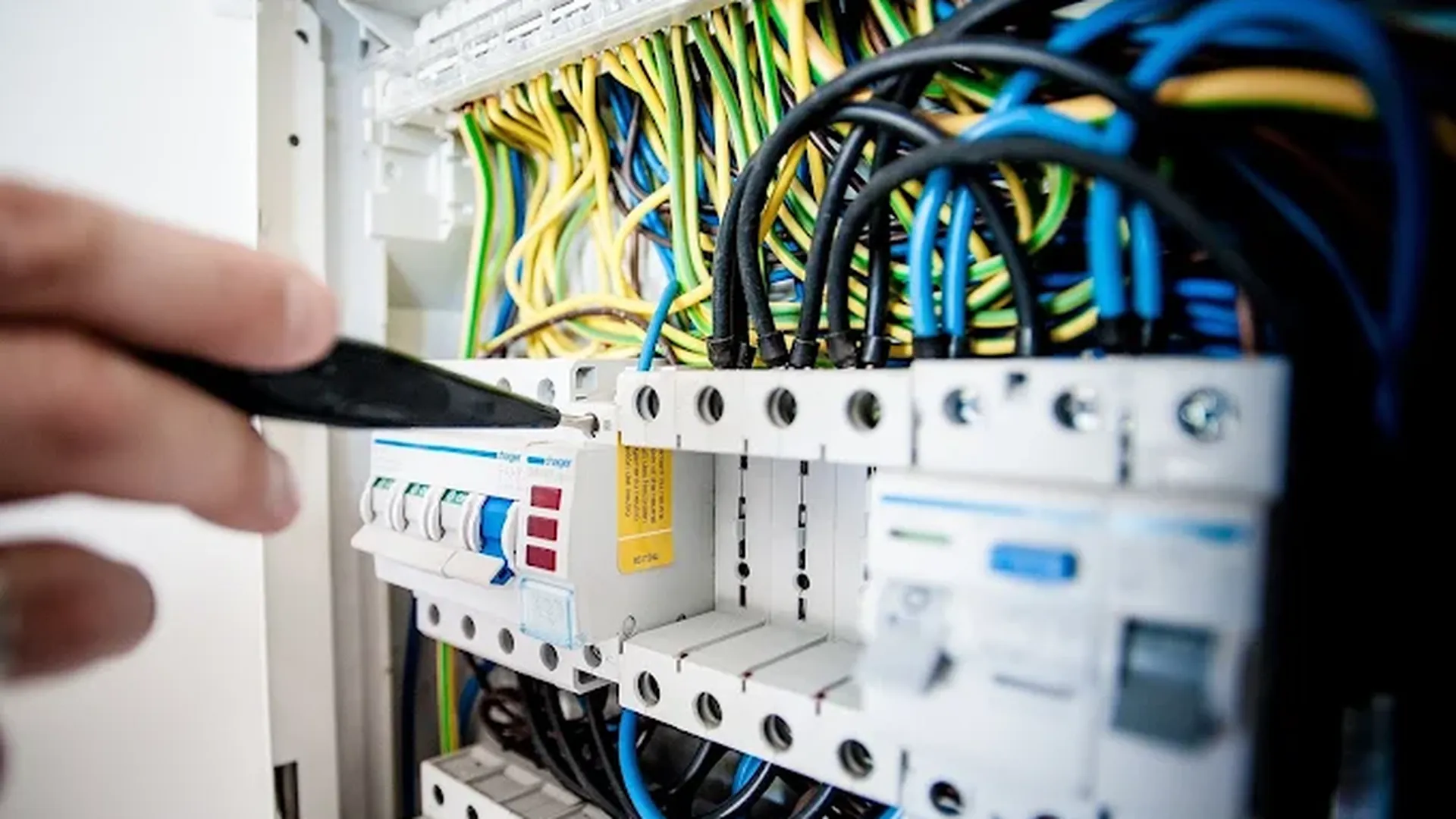 Electrician in Manchester working on circuit breakers in a consumer unit