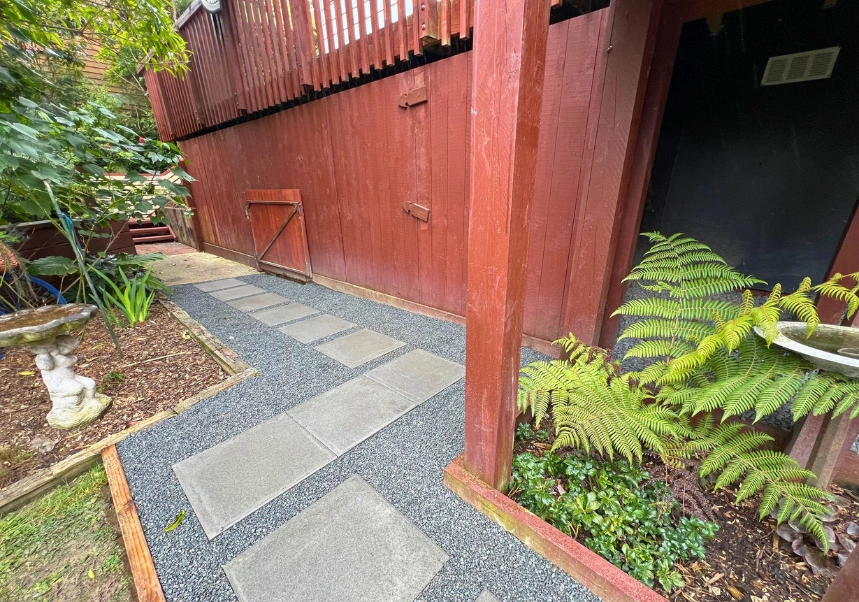 Wide view of landscaped garden with wooden stair panels and Firth paver path