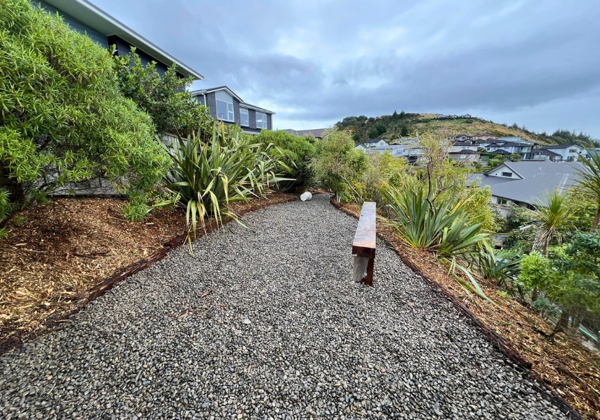 Garden beds with new bark mulch and natural stone accents overlooking the bay