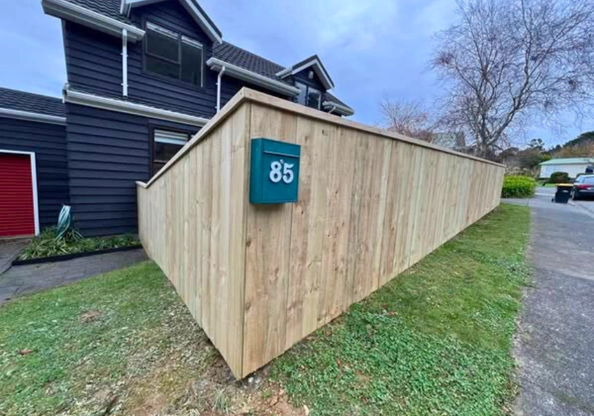 Landscape view of property entrance with custom wooden gate and fencing