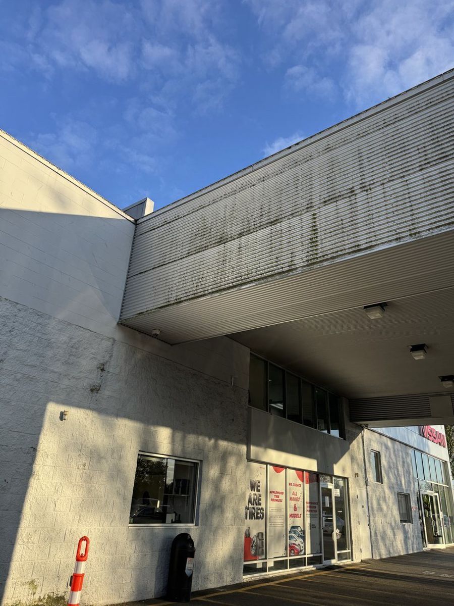 Before: ribbed metal canopy panel covered in black streaks at Applewood Nissan