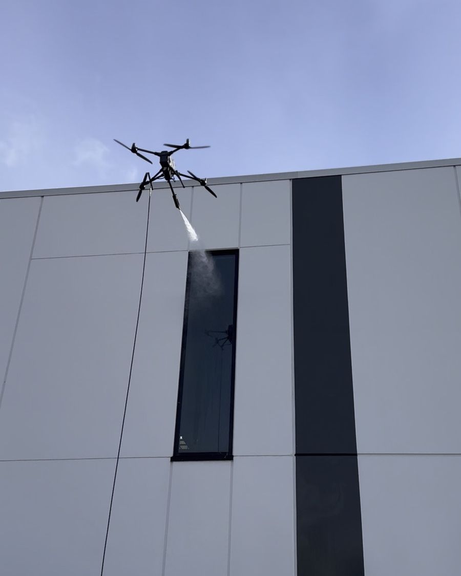 Drone rinsing a window with pure water