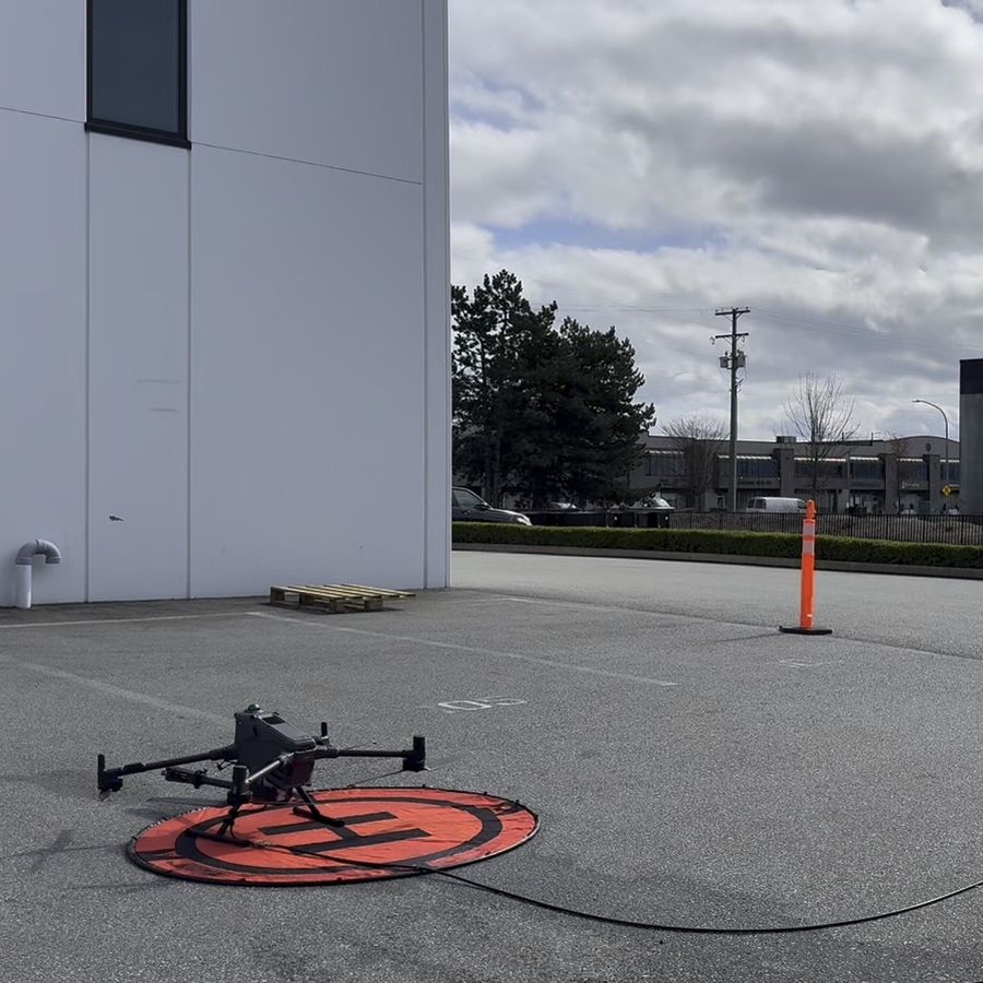 Cleaning drone on its landing pad with a cone marking the work zone