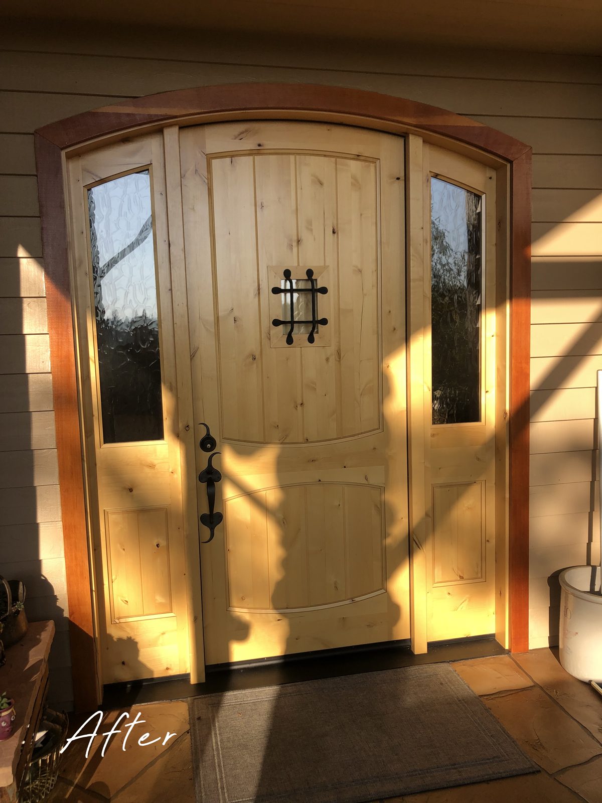 New arched wood entry door with sidelights after installation