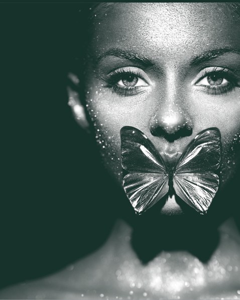 A face in black and white with a butterfly resting over the mouth