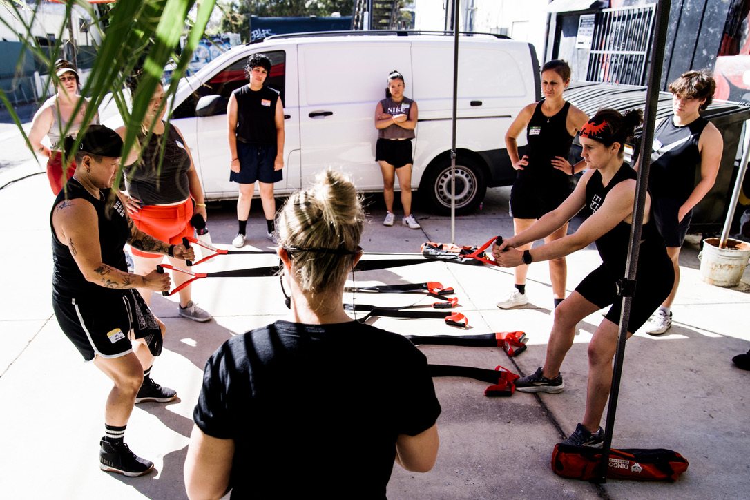 Members training with suspension straps in an outdoor class