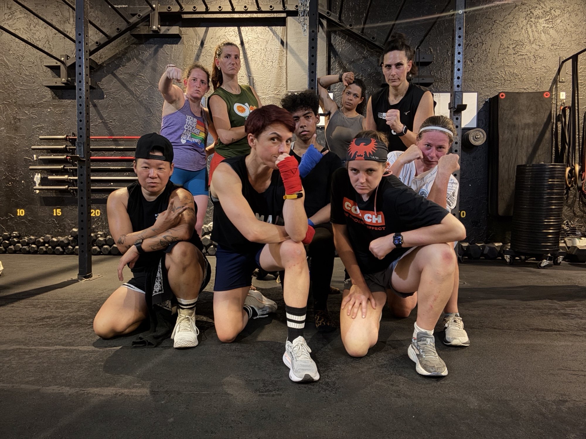 Lesbian Fight Club members in hand wraps striking a fight pose in the gym