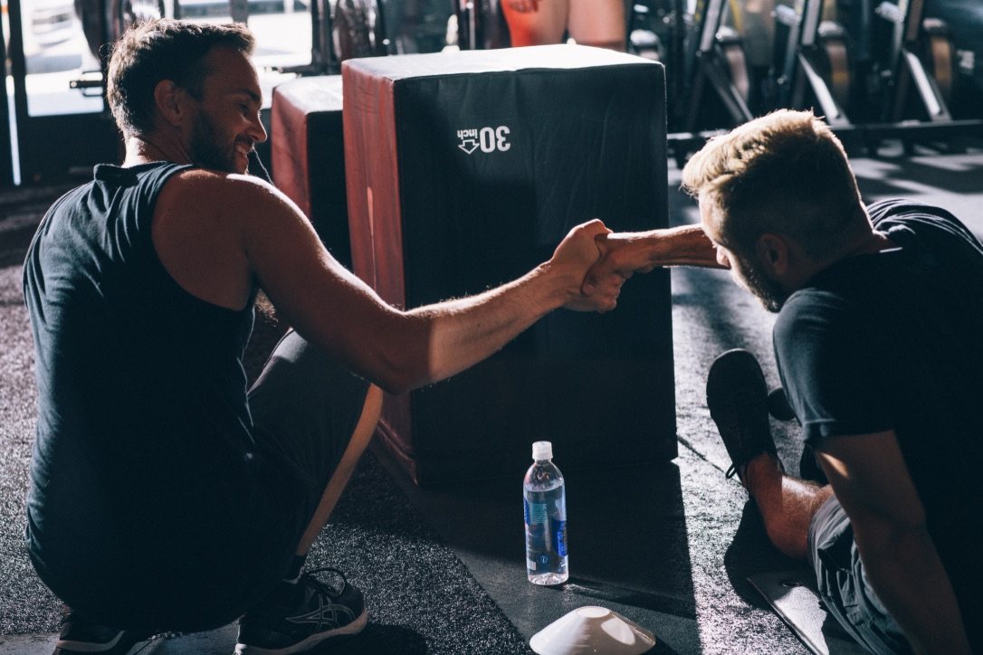 A TPE coach and member sharing a fist bump between sets