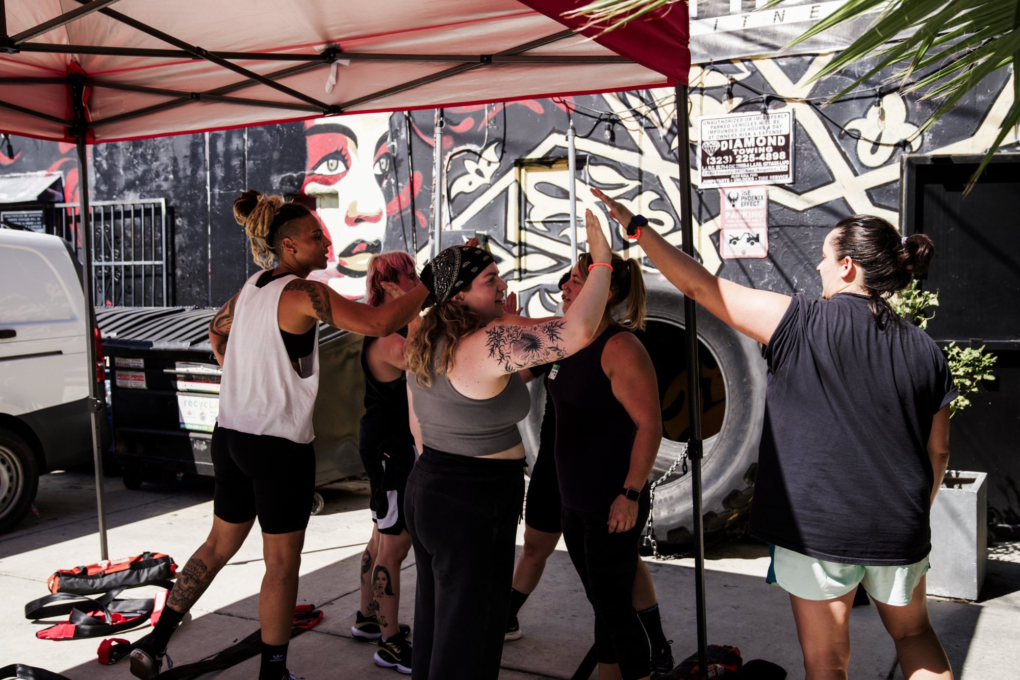 Members high-fiving after an outdoor workout