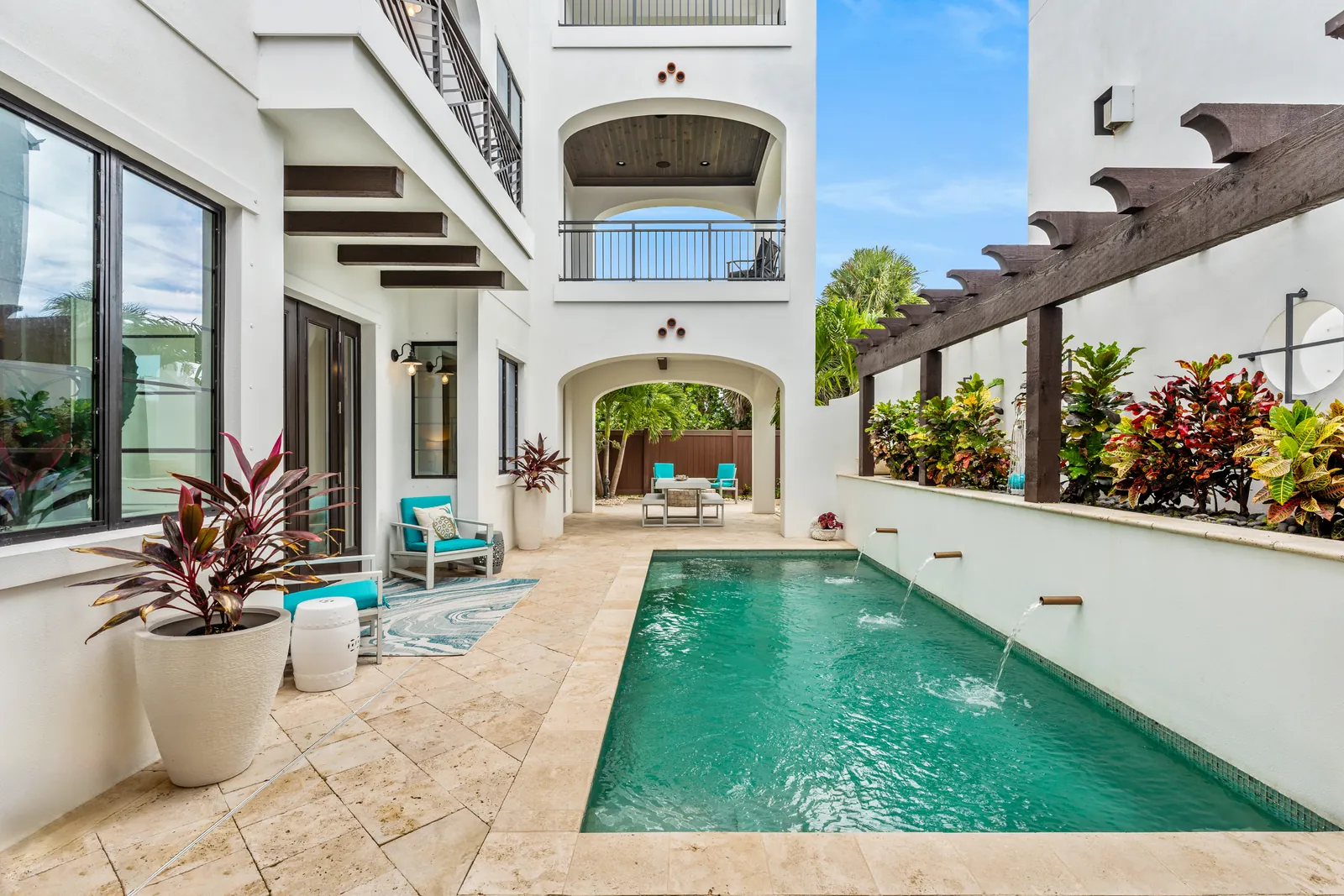 Turquoise courtyard pool framed by white arches