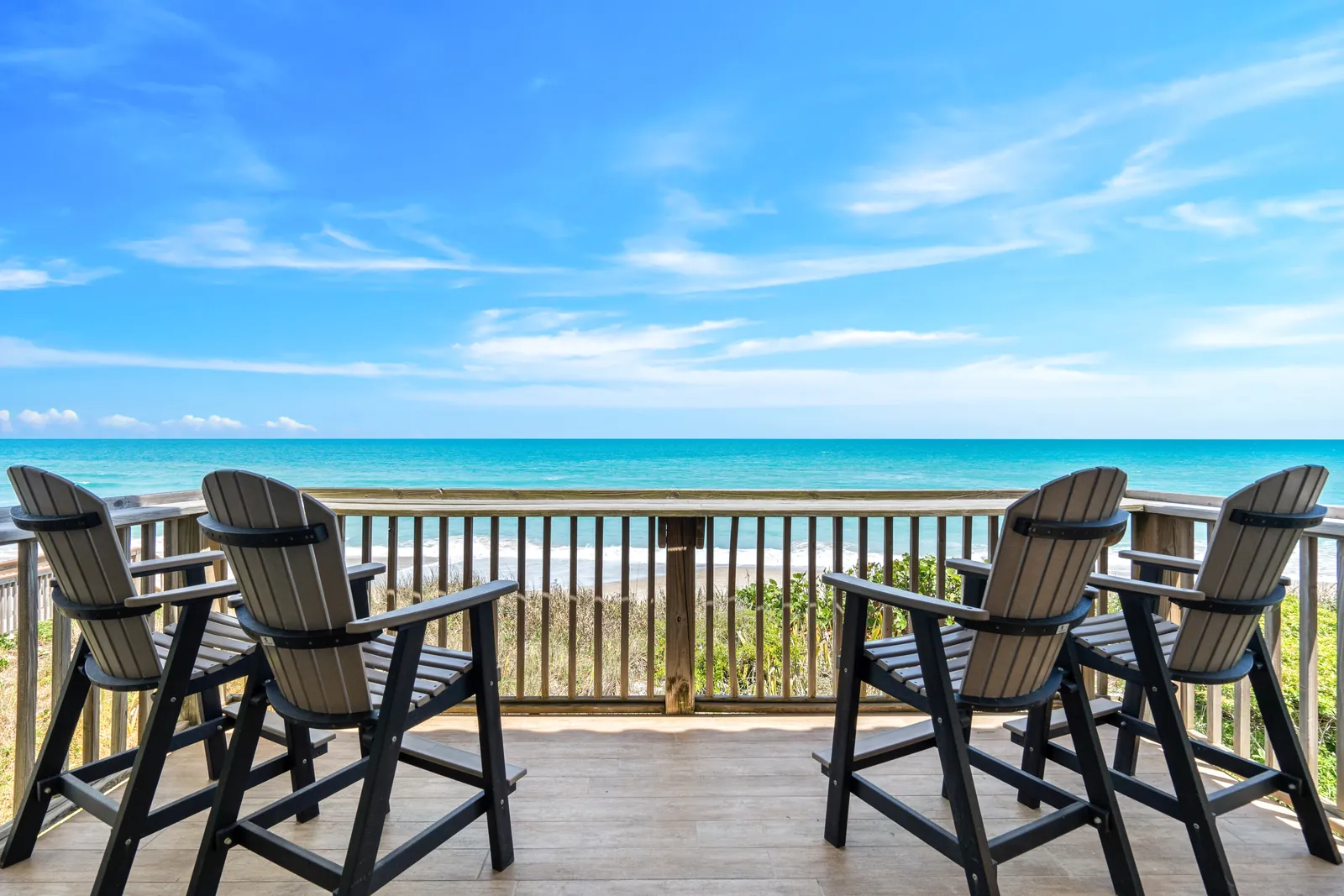 Oceanfront deck with four chairs facing the water