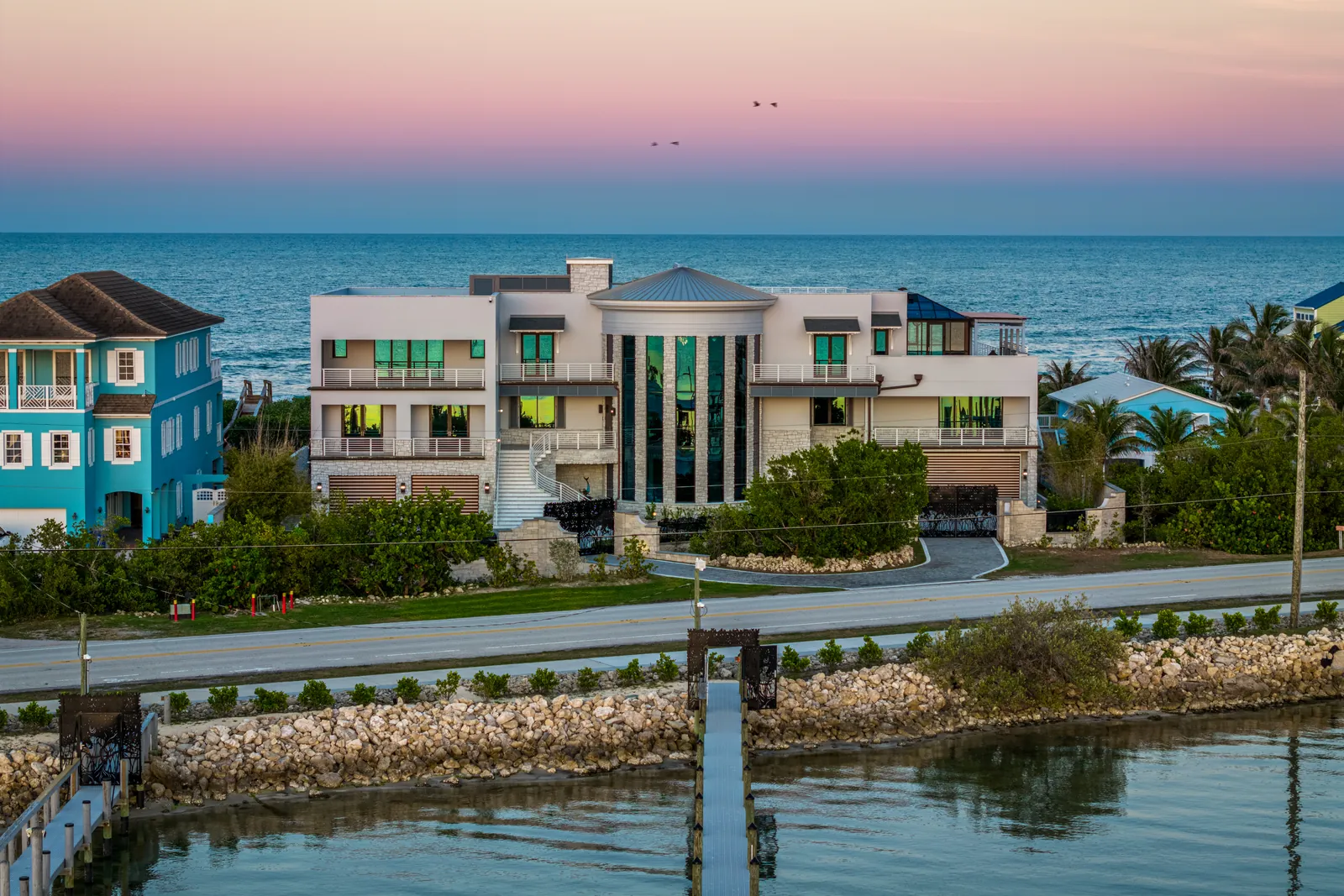 Coastal home beneath a pink-and-blue dusk sky