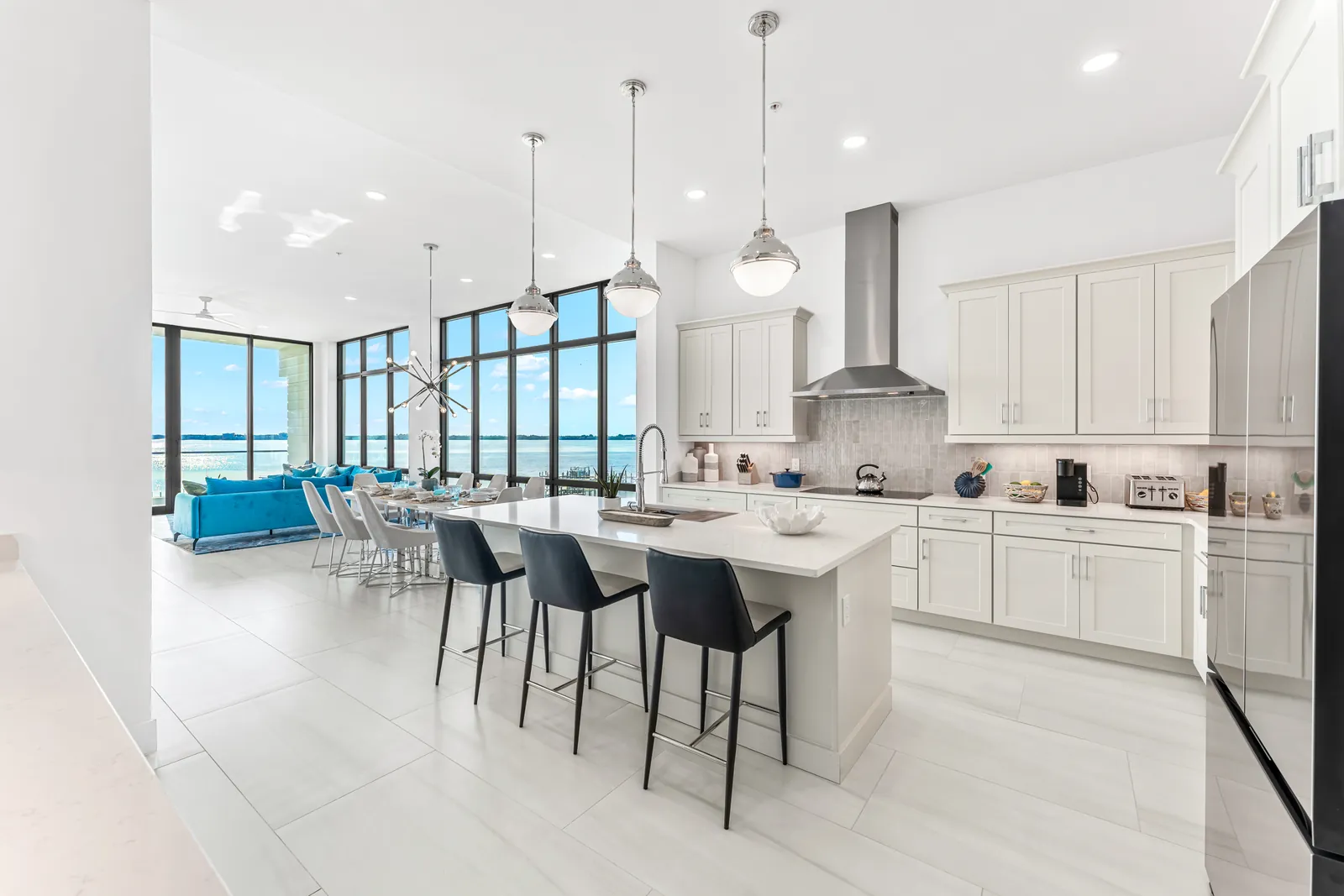 Wide white kitchen opening into a waterfront living area