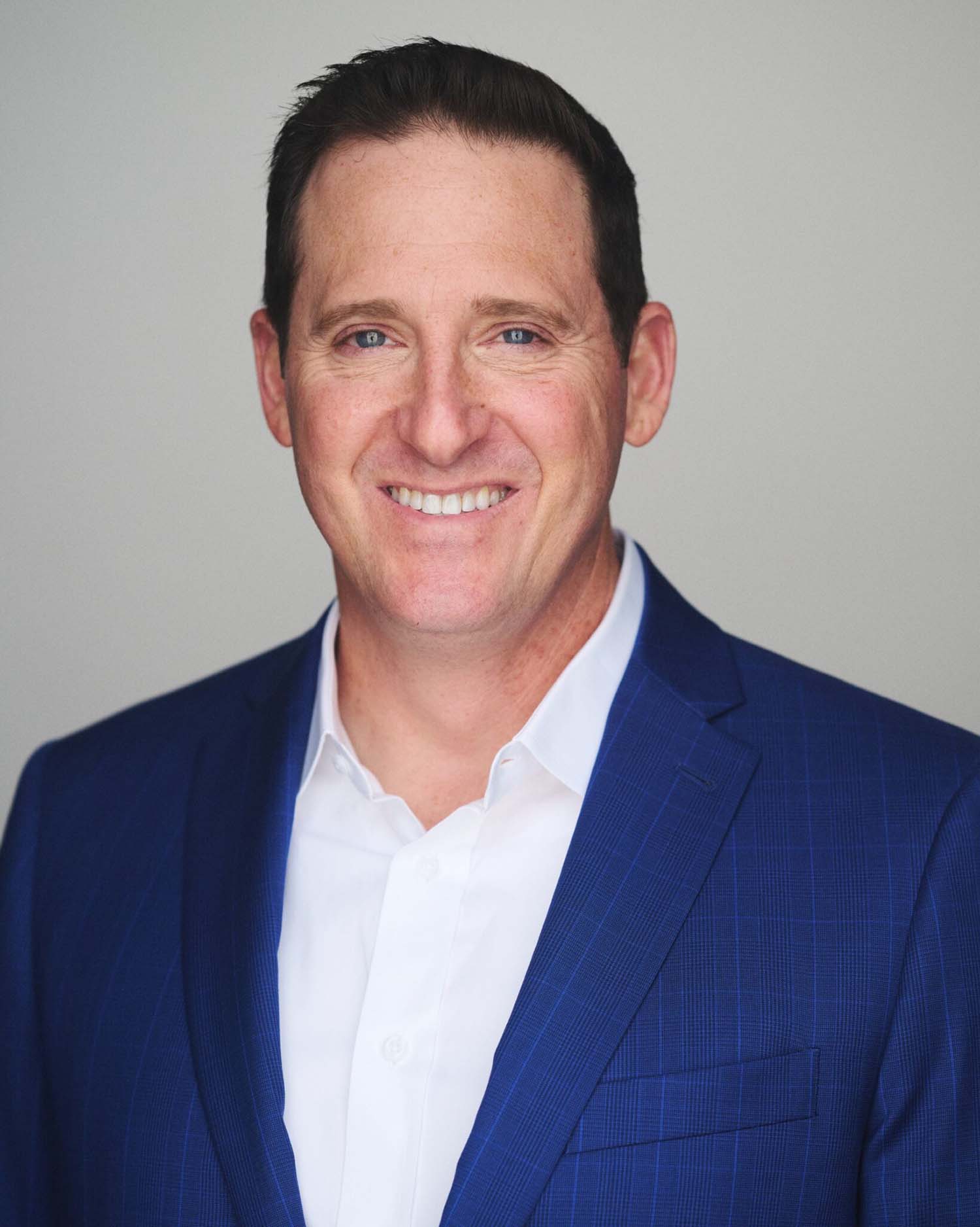 William Young smiling in a blue suit and white shirt