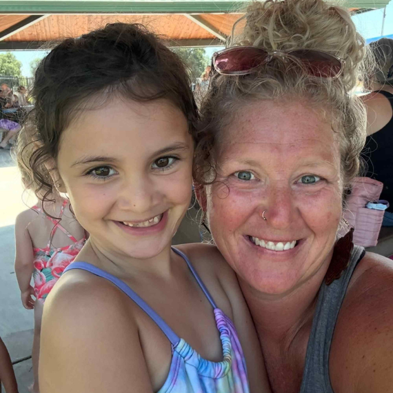 Mother and daughter smiling happily outdoors, a family-centered early intervention outcome