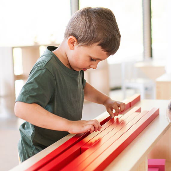 Young boy assembling learning blocks with collaborative specialist support