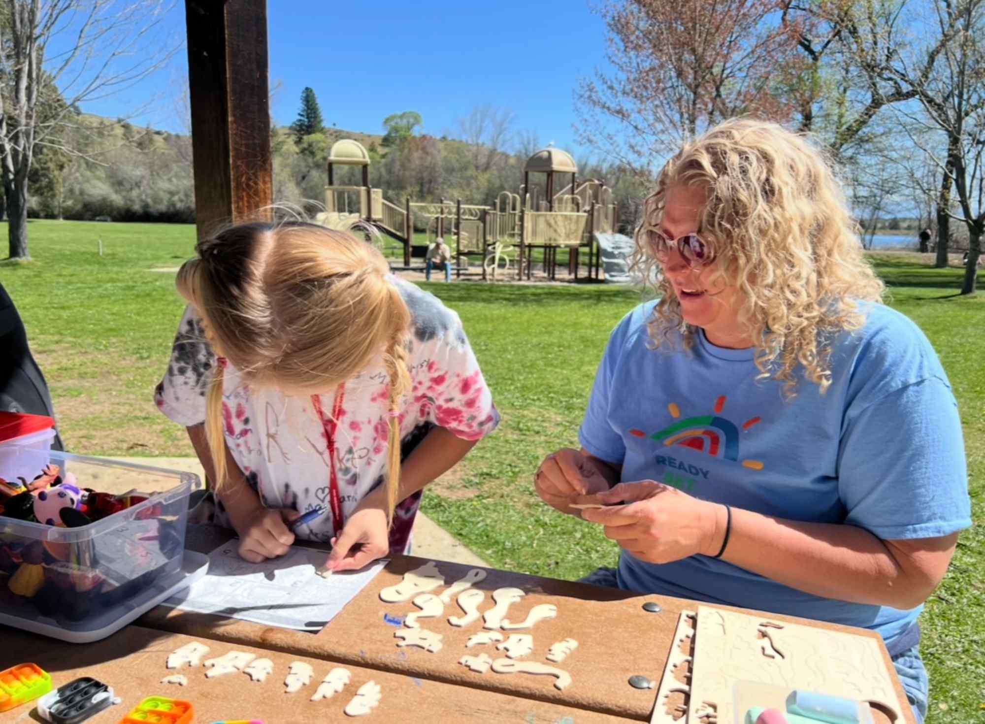 Children learning outdoors at park table
