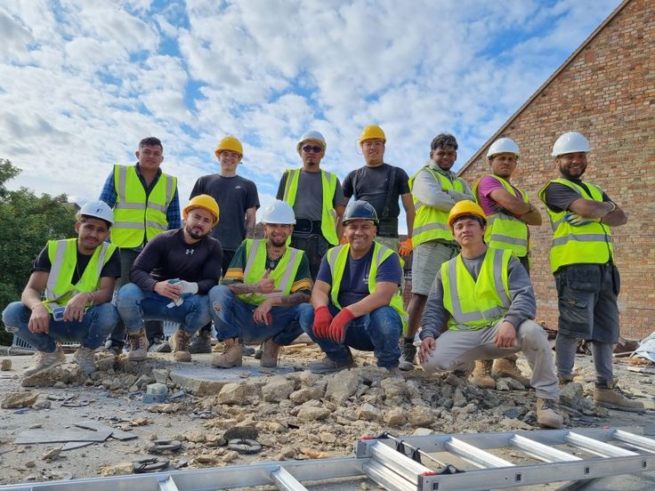 IronPeak Roofing crew in crimson shirts and hard hats in front of a work truck