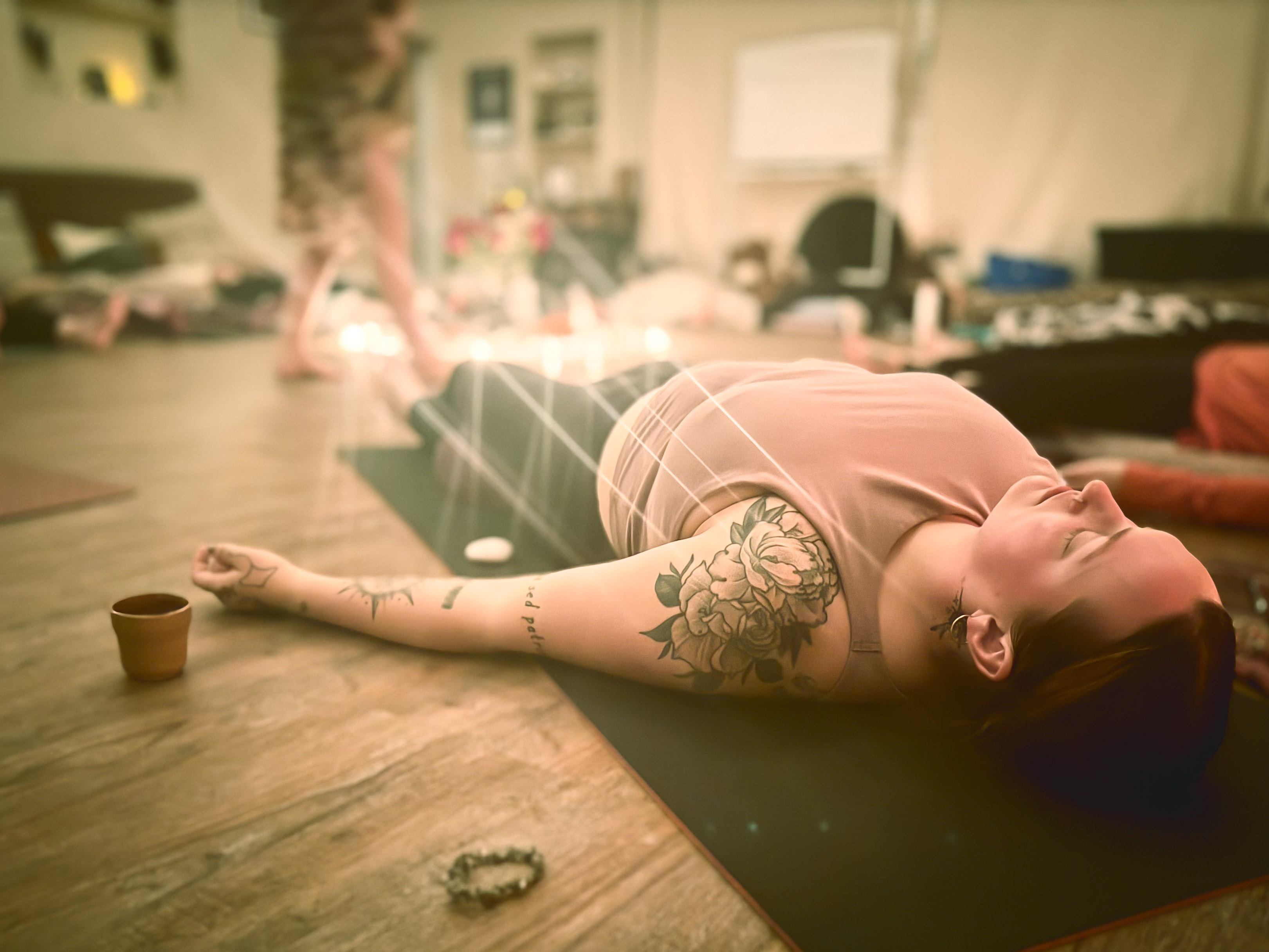 Guest resting with candles during a Yoga Nidra deep rest