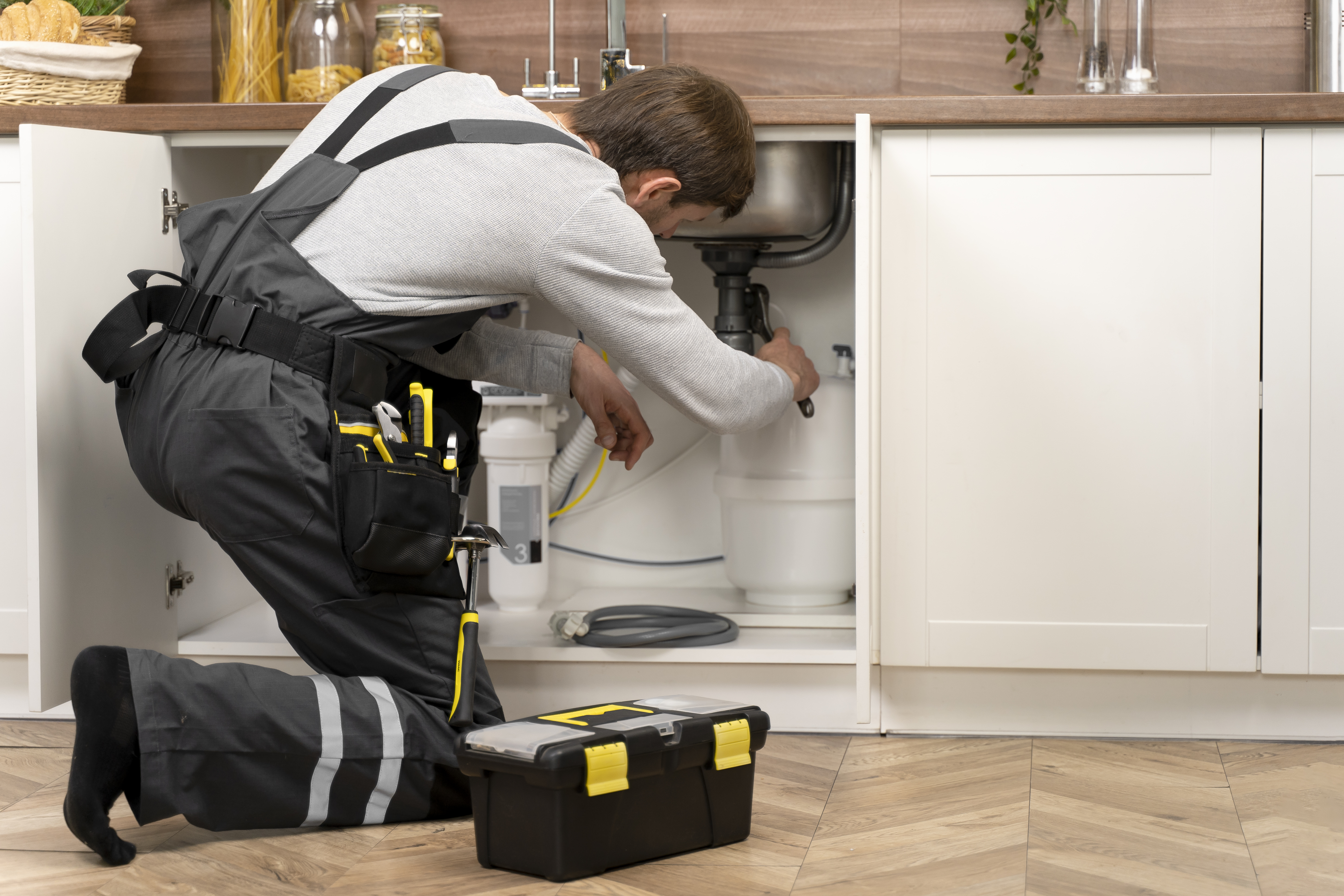 Loodgieter repareert lekkage onder gootsteen – Automation-Plan voor sanitairbedrijven