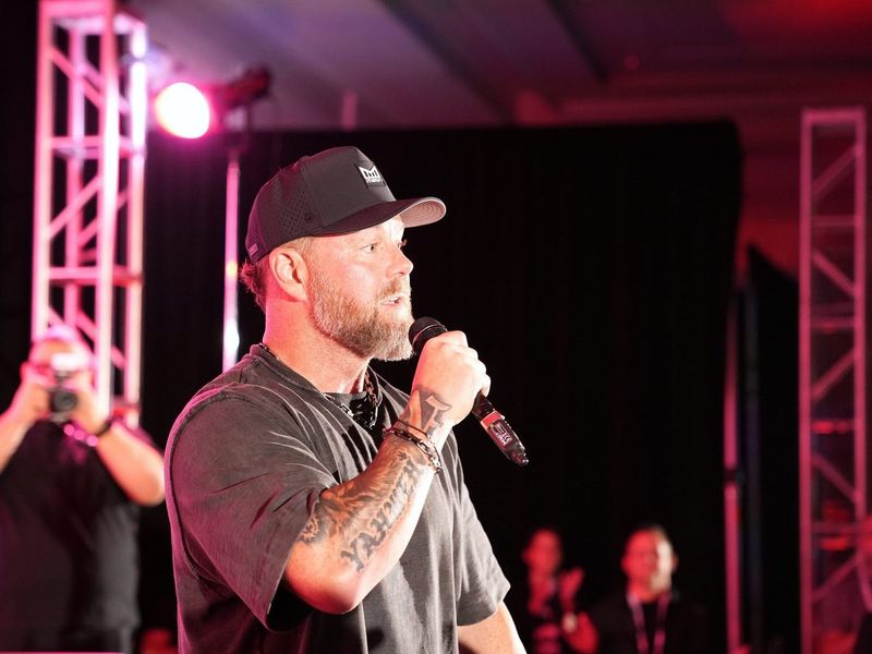 Speaker with microphone under stage lights at a live event