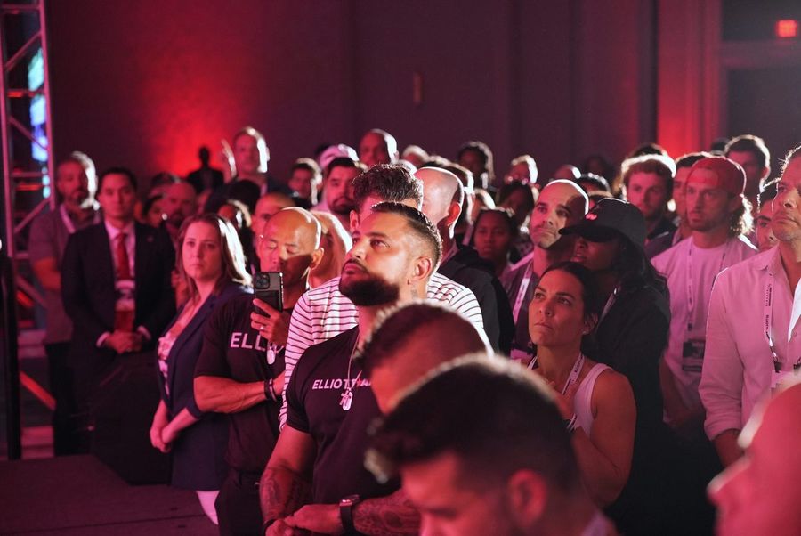 Packed conference audience in dramatic red light