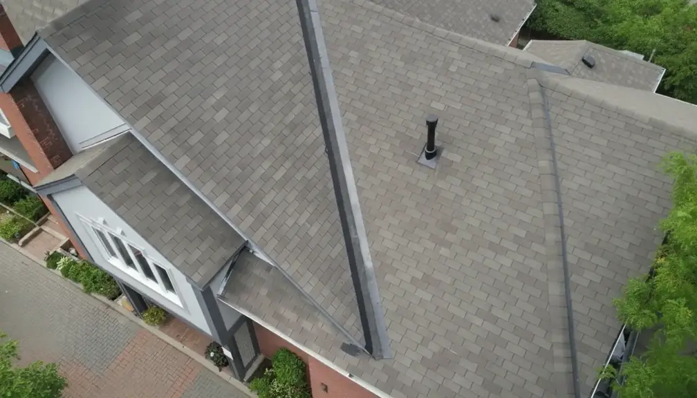 Aerial view of newly repaired residential roof with uniform shingles and clean finish after restoration work