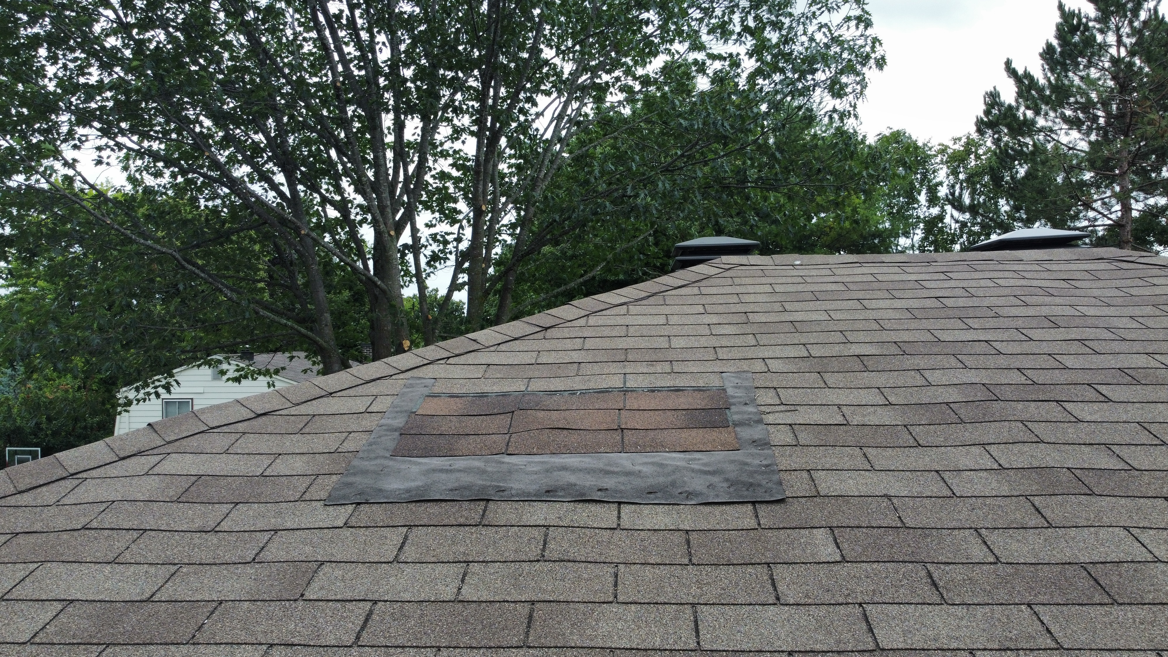 Home with newly installed roof and skylights, featuring clean lines and durable shingles after project completion