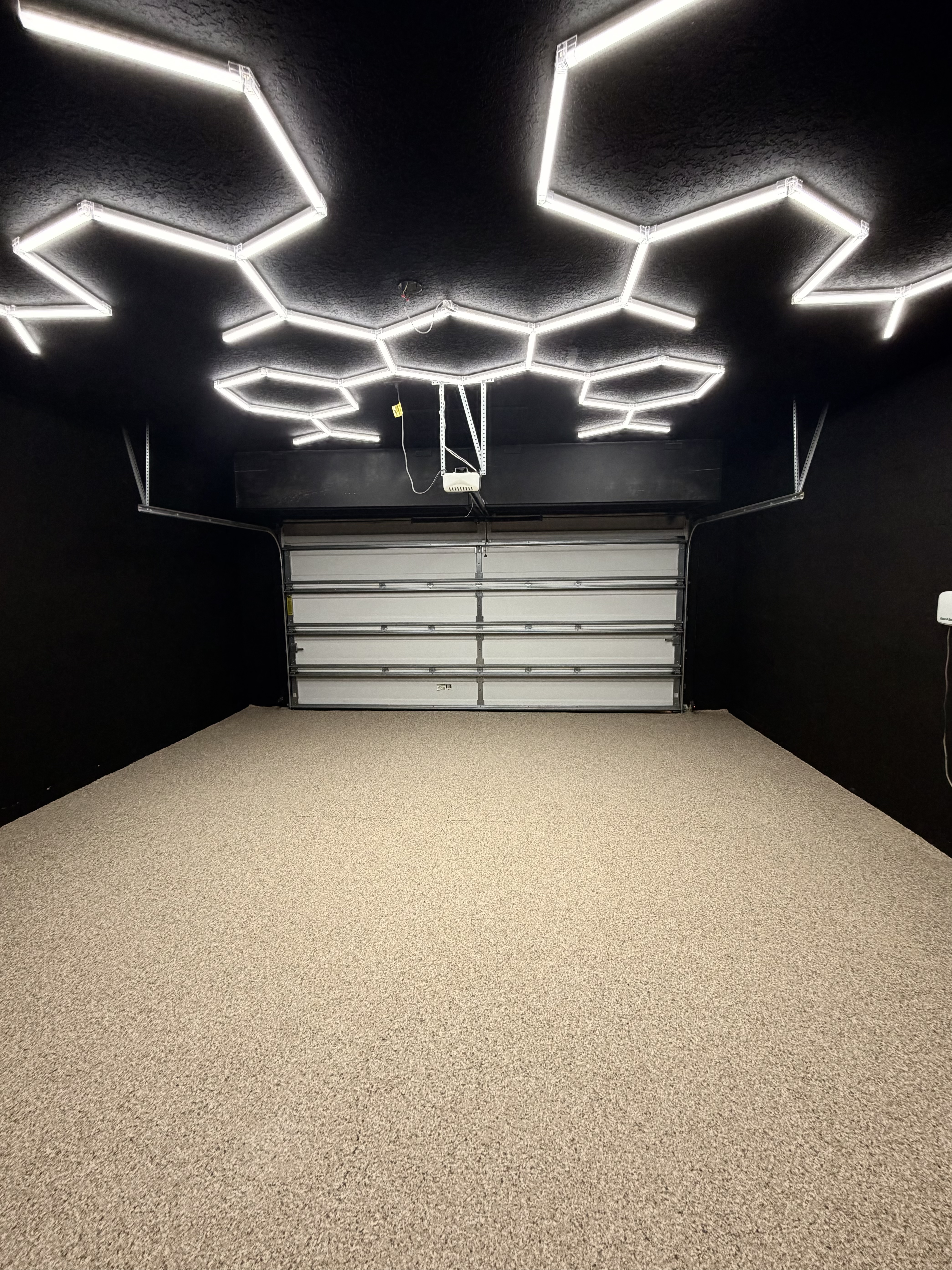 black walls hexagon lighting and tan floor