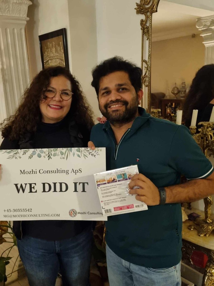Mozhgan celebrating a new job with a client, holding a "We did it" sign