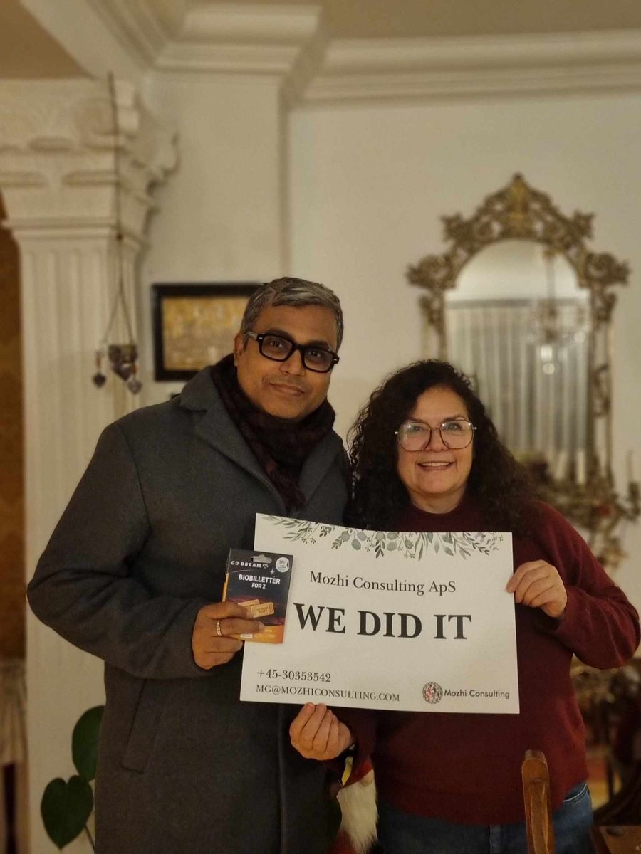 Mozhgan celebrating a new job with a client, holding a "We did it" sign