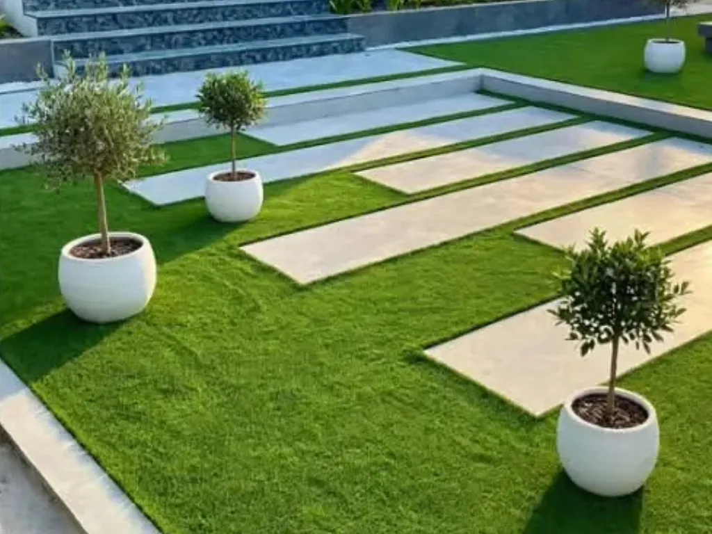Finished terraced garden with white raised beds and paved stepping-stone paths by Mis-tic Landscaping