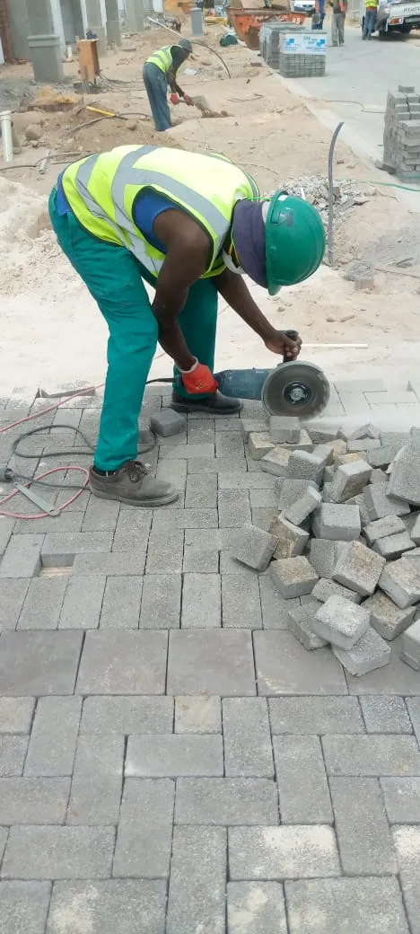 Mis-tic crew cutting paving blocks with an angle grinder