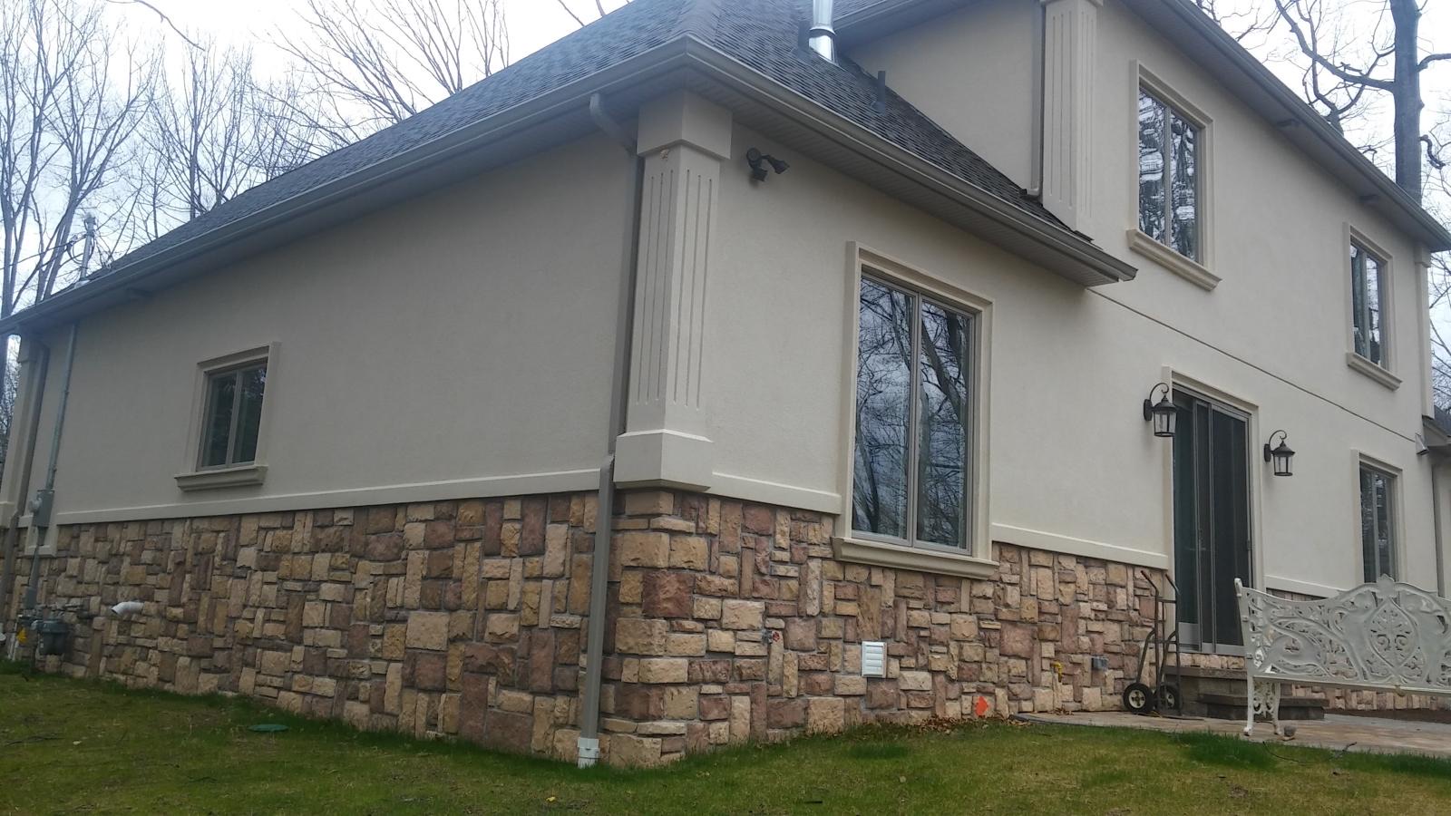 Two-story home with a stucco and stone exterior and large windows