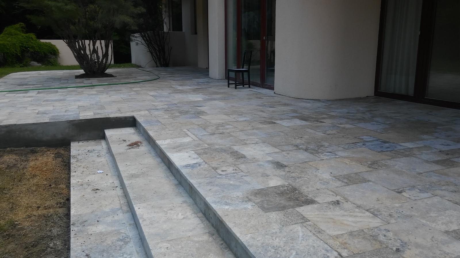 Stone-tile patio with a seating area beside a glass door