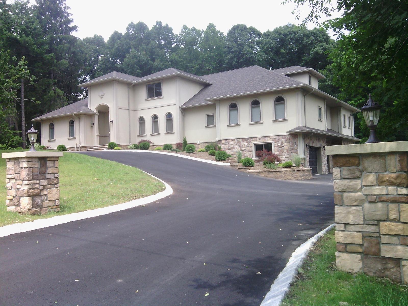 Two-story Hudson Valley home with a curved driveway and a landscaped yard