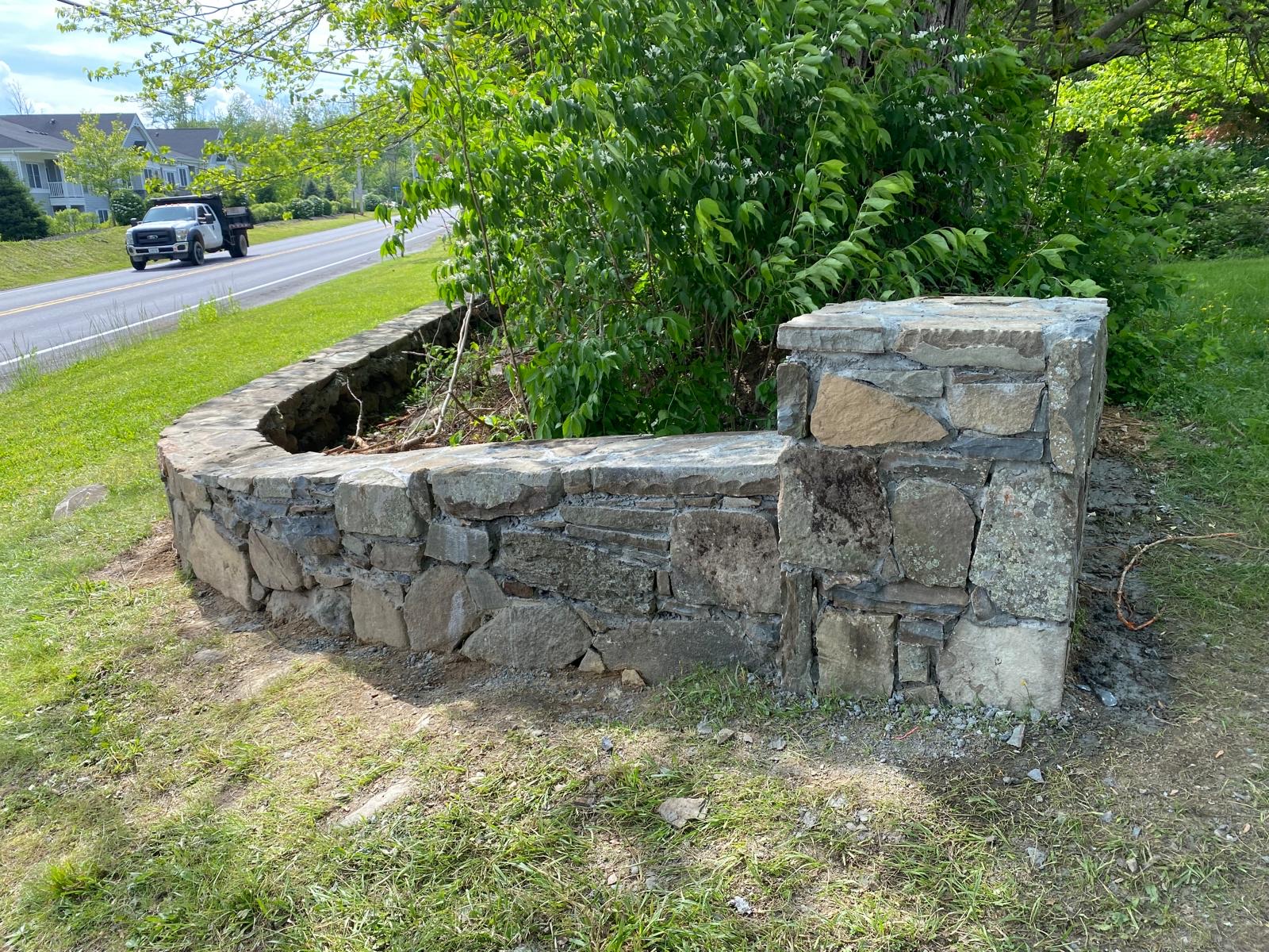 Dry-stack stone wall lining a property near a roadside