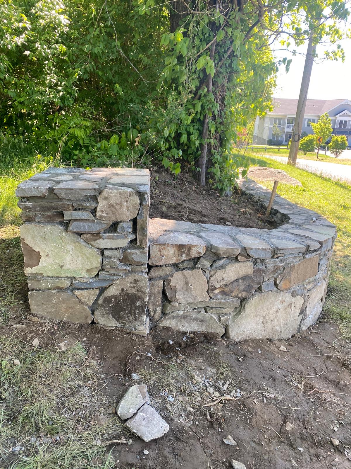 Natural stone retaining wall built in a grassy Hudson Valley yard