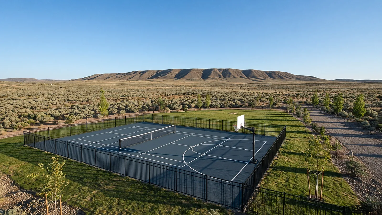 Multi-use backyard sport court with pickleball lines and basketball half court on an acreage lot in Kuna, Idaho
