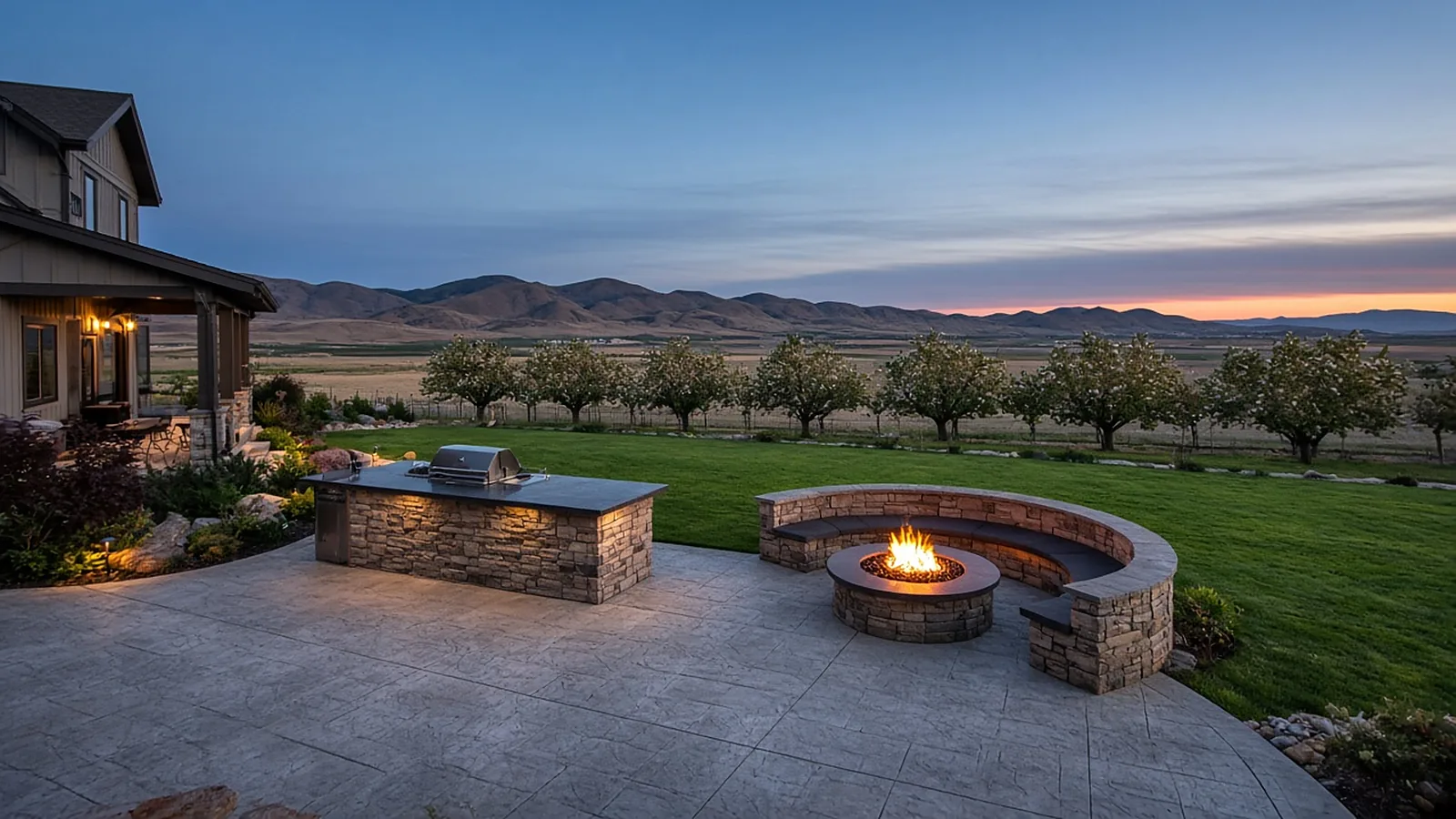 Acreage backyard in Emmett, Idaho with outdoor kitchen, fire pit, and patio beside orchard rows