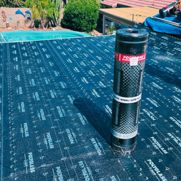 Professional application of Polyglass roofing membrane on a flat patio roof near a swimming pool in a Mesa residential neighborhood.