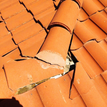 Close-up of cracked and slipping clay roof tiles on a home in a Queen Creek community, requiring professional tile roof repair.